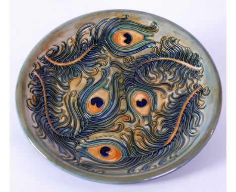 SECOND QUALITY MODERN MOORCROFT 'PEACOCK FEATHER' TUBE LINED POTTERY PLATE,  decorated in tones of orange, blue and green, on