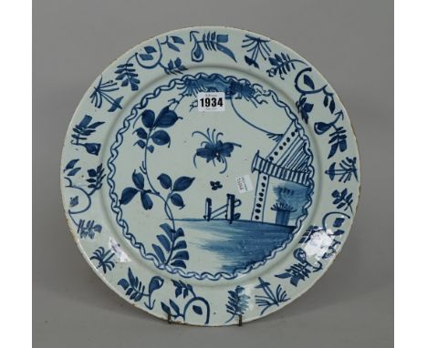 An English delftware blue and white plate, mid-18th century, painted with an insect, flowers and a tent, 33cm. diamter.