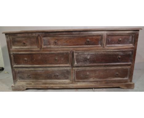 A 20th century Indian hardwood low chest, with three short and four long drawers on bracket feet, 153cm long x 75cm high. 