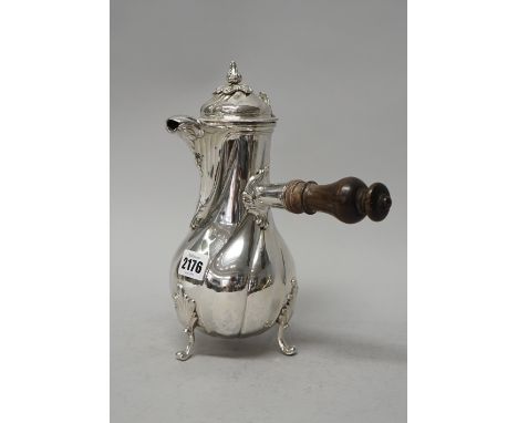 A European silver coffee pot of baluster form, the body with swirl decoration raised on three foliate capped feet, the hinged