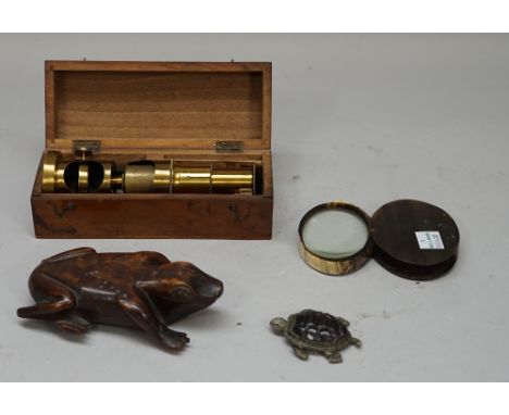 A white metal novelty vesta cast as a tortoise and dated 1911, 6cm, a carved wooden 'frog' snuff box, 13cm, a horn magnifying