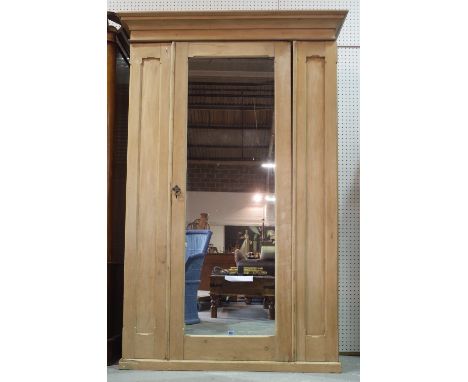 An early 20th century pine double wardrobe with mirrored central door on plinth base, 131cm wide x 200cm high. 