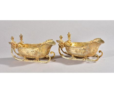 A pair of late Victorian silver gilt sauceboats of novelty "sleigh" form, William Comyns, London, 1897, lantern finials and c