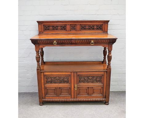 Gillow &amp; Co; a Victorian carved oak buffet with pair of drawers over cupboard on baluster supports, stamped to drawer and