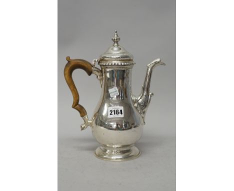 A silver coffee pot, of baluster form with a decorated spout and with a fluted finial to the hinged lid, in the 18th century 