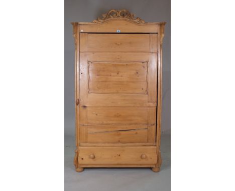 An early 20th century arch top pine single door wardrobe, with single drawer to base on bun feet, 102cm wide x 180cm wide. 