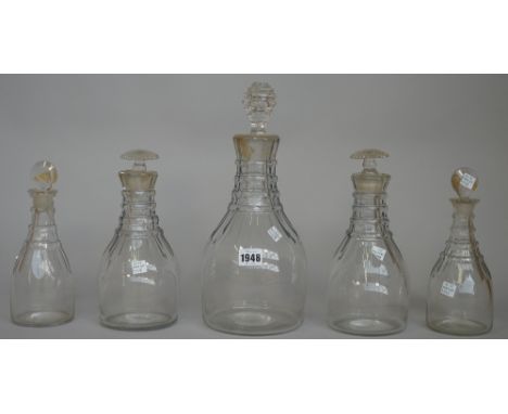 Five Prussian shaped decanters, early 19th each cut with flutes at the shoulders beneath ring necks, comprising; a magnum dec