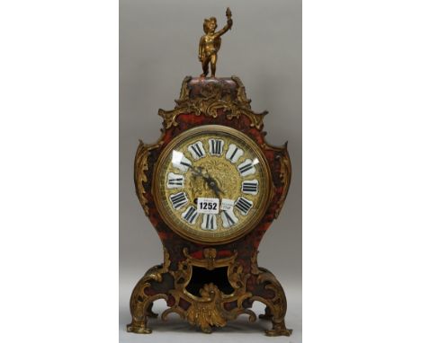 A French boulle work mantel clock of waisted form, 19th century, with cherub surmount and foliate embellished gilt metal case