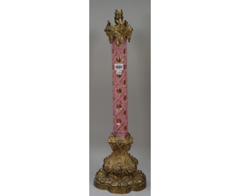 A Victorian cased glass and gilt metal mounted table lamp of column form, the circular mottled pink body with thumbnail cut d