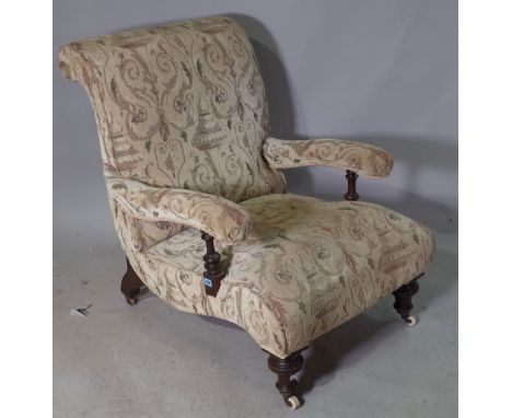 A Victorian mahogany framed low open armchair on ring turned tapering supports.
