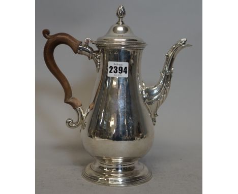 An early George III silver coffee pot, of baluster form, raised on a plain circular foot, the hinged lid with a wrythen knop 