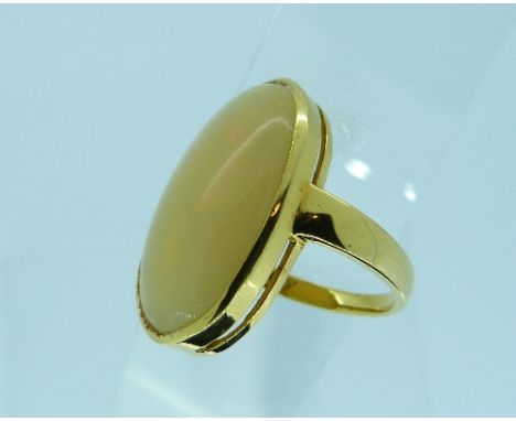 A large oval opal Ring, set with a milky opal with flashes of green and orange, in a yellow gold mount marked 750, Size N½.