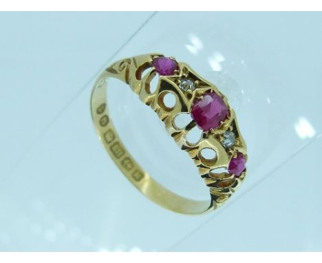 A five stone ruby and diamond Ring, with three pale oval rubies and two circular cut diamond in between, in an 18ct yellow go