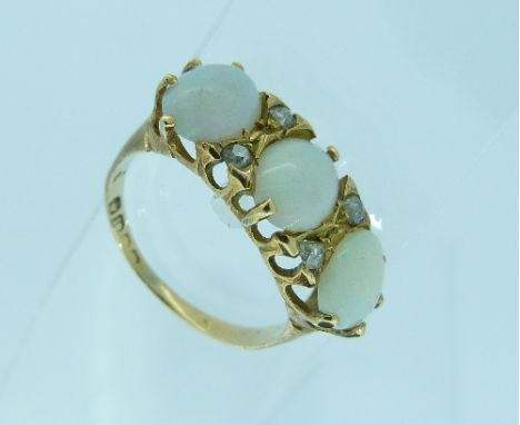 A three stone opal Ring, one damaged, with four diamond points between, all mounted in 18ct yellow gold, Size M.