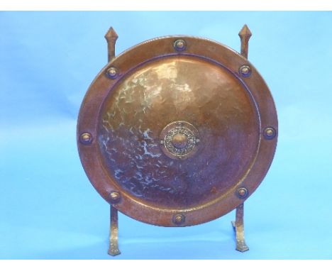 An Arts & Crafts copper-coloured metal Fire Screen, of concave circular shield-shaped form, 23in (58.5cm) diameter, together 