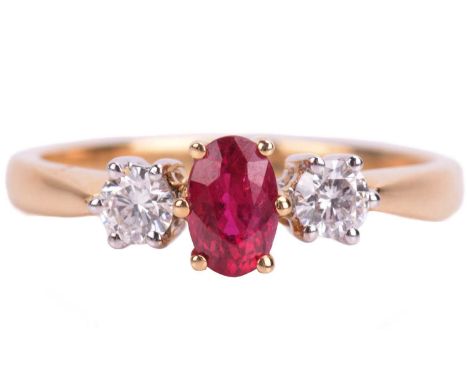 A ruby and diamond trilogy ring in 18ct yellow gold, centred with an oval-cut ruby of purplish-red colour, approximately meas