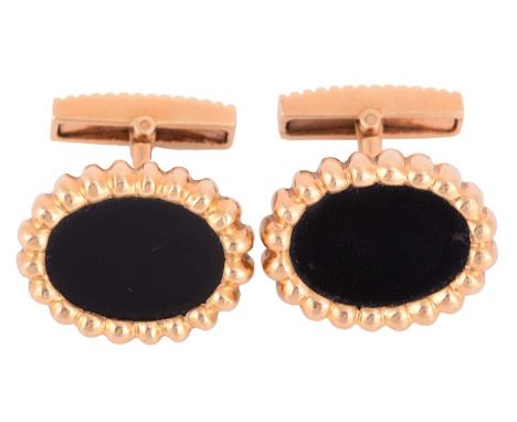 A pair of onyx-set cufflinks, each inset with an oval onyx panel within a lobed surround, fitted with toggle backs, yellow me