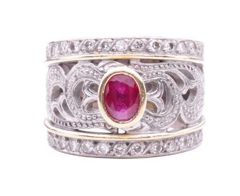 A ruby and diamond dress ring, the bezelled oval ruby measuring approximately 6mm x 4.5mm, centrally set in a pierced mount w