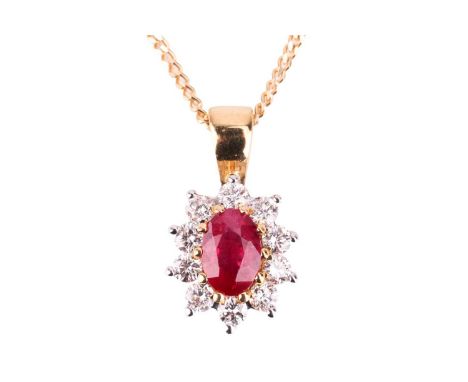 A ruby and diamond cluster pendant, set in 18ct bi-colour gold, featuring an oval mixed cut ruby of deep pinkish-red colour, 