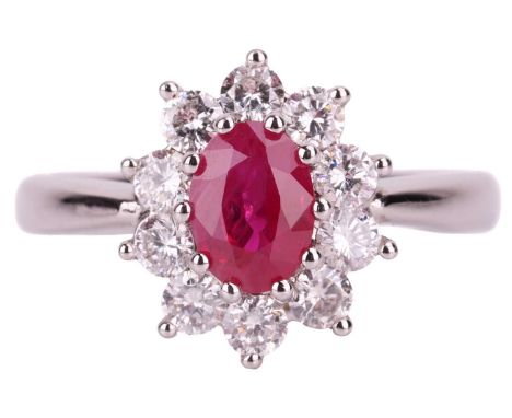 A ruby and diamond halo ring in 18ct white gold, centred with a flux-healed ruby of 7.2 x 5.2 x 3.3 mm, encompassed by ten br