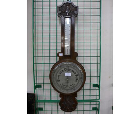 An early 20th Century carved oak aneroid barometer