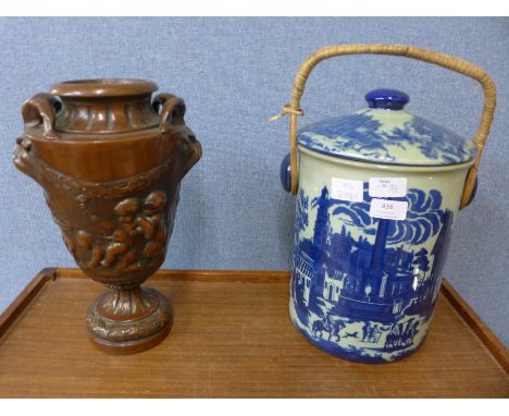 An ironstone crock with blue and white continental scene decoration and an urn decorated with cherubs and grotesque mask hand