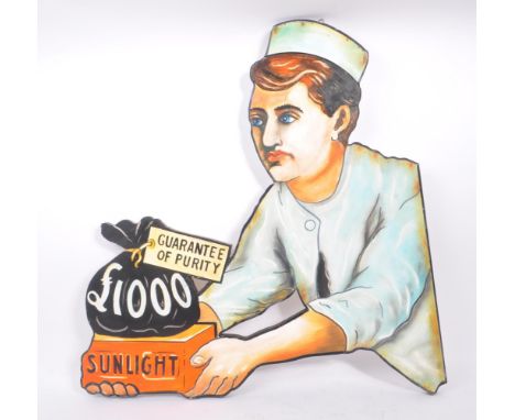 A reproduction faux enamel hand painted Sunlight soap advertising board picture. The sign featuring a man holding a block of 