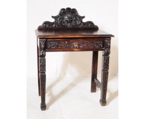 A Victorian 19th century carved oak side / hall / console table. Having a carved shaped gallery back, rectangular chamfered e