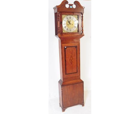 An early 19th century oak inlaid brass faced longcase grandfather clock. The case having crested pediment with finial and cen