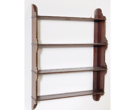 A Victorian 19th century mahogany hanging bookcase. Raised on shaped panel sides with a series of four fixed shelves having g