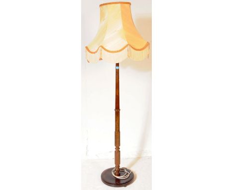 A vintage 20th century floor standing standard lamp. Of mahogany construction with central turned column, light fittings to t
