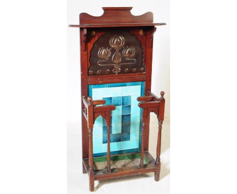 A Victorian 19th century Arts &amp; Crafts oak hall stand with tile back and stick stand front. Carved panel above with shelf