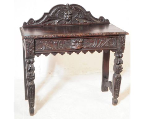 A 19th century Victorian Gothic Revival gallery back oak console hall table. The table having carved gallery serpentine heavi