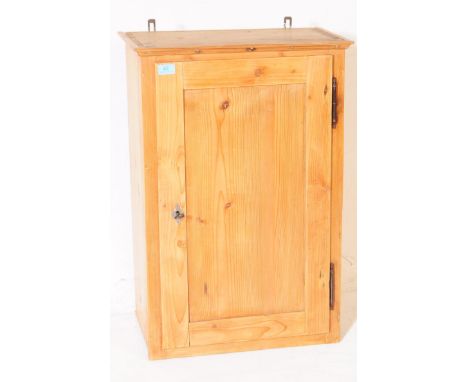 A 20th century pine wood wall hanging cupboard. The cupboard having a flared cornice to top, with single door to front featur