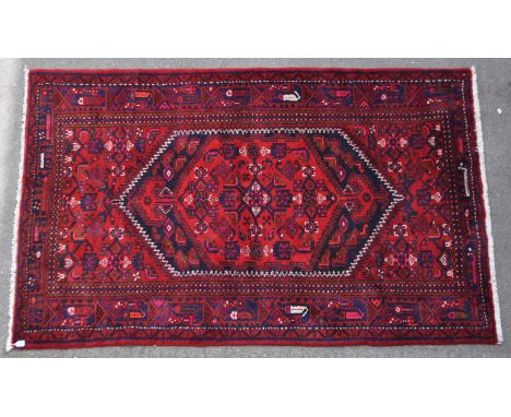 A mid 20th century Persian Malayer hand knotted carpet floor rug. The rug having a red ground with dense woollen pile. Having