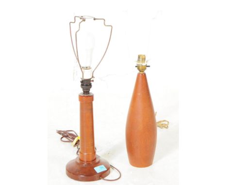 Two mid 20th century teak wood table lamps. One lamp being of tapered oval form, with the other having a rounded base below a