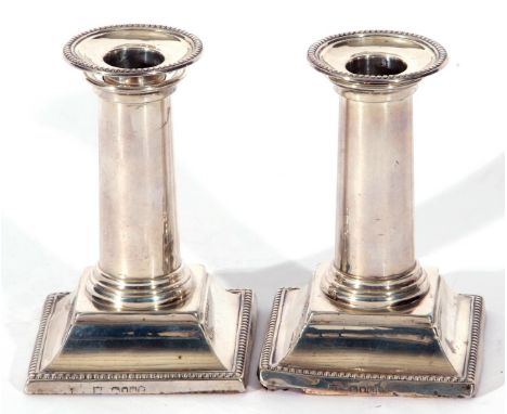 Pair of Victorian silver desk or dwarf candlesticks on square bases, with beaded edges, the plain circular column with Doric 