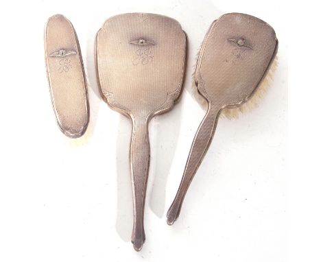 Elizabeth II silver backed dressing table brush and mirror set, comprising two brushes and a single hand mirror, the backs de