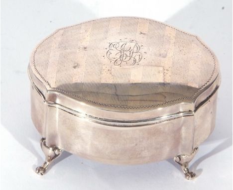 George V silver ring box of shaped oval form, the slight domed lid with central monogram between engine turned engraved bands