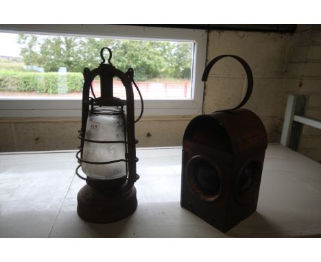 A hanging lantern and a red painted road lamp 