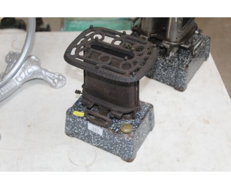 A vintage paraffin heater with a single burner with cast iron mottled enamel base