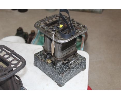 A vintage paraffin heater with a double burner and cast iron mottled enamel base