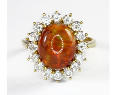 An 18ct yellow gold cluster ring set with a cabochon cut fire opal surrounded by diamonds, (L.5).