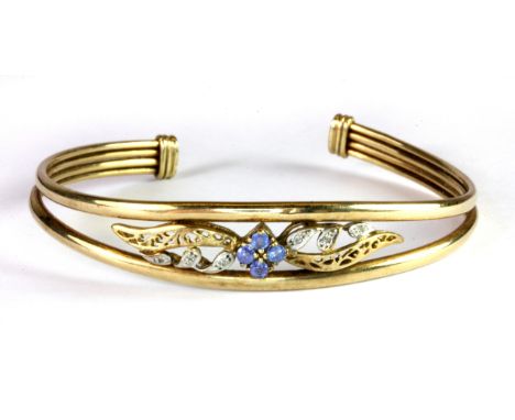 A yellow metal (tested 9ct gold) sapphire and diamond set adjustable bangle.