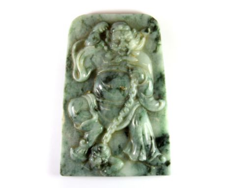 A superbly carved Chinese mixed colour jadeite jade panel (probably from a table screen) of a guardian deity, with a figure i