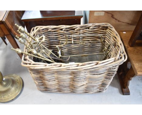 A large vintage basket and selection of antiques brasswares including paper rack and fire tools etc