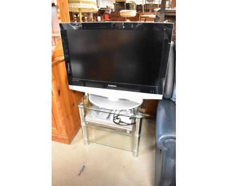 A Samsung TV , Panasonic VHS/DVD.HDD recorder, and glass stand