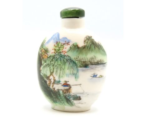 A hand painted Chinese porcelain snuff bottle with landscape decor & jade stopper, 71mm tall