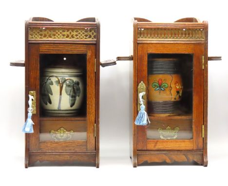 Two oak pipe smokers cabinets with tobacco jars, gallery top & pipe racks