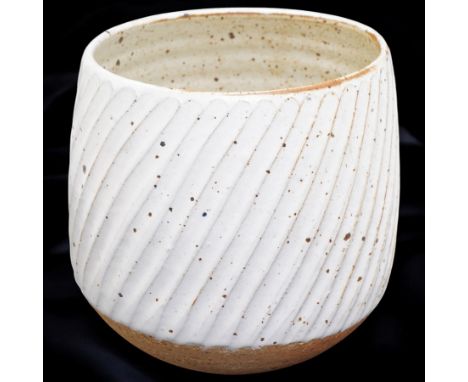 Joanna Constantinidis (1927-2000); studio pottery stoneware vase with fluted body, in a white glaze with brown speckles, impr